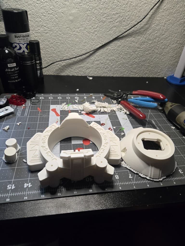 White 3D-printed Max prop components laid out on a cutting mat before finishing