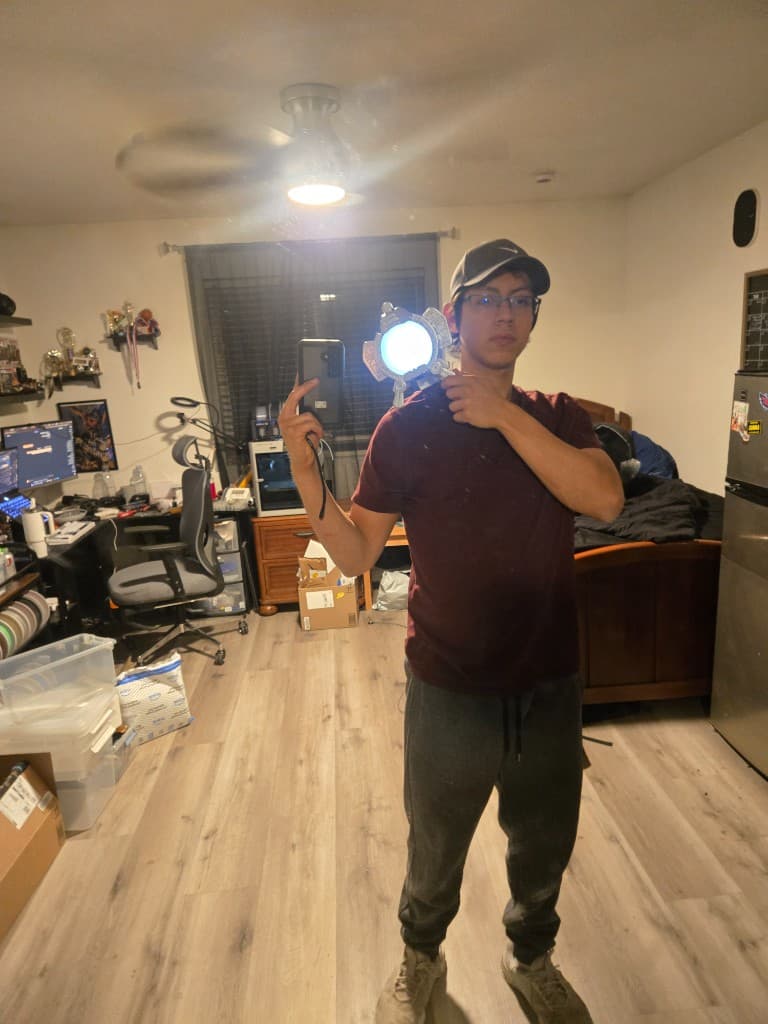 Mirror selfie holding the illuminated Max prop at shoulder height to test the single-point magnetic mount