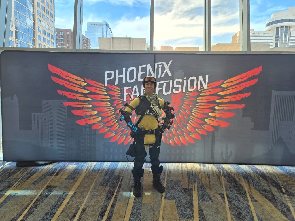 Mirage cosplay at Phoenix Fan Fusion with glowing holo gauntlets and phoenix wings backdrop